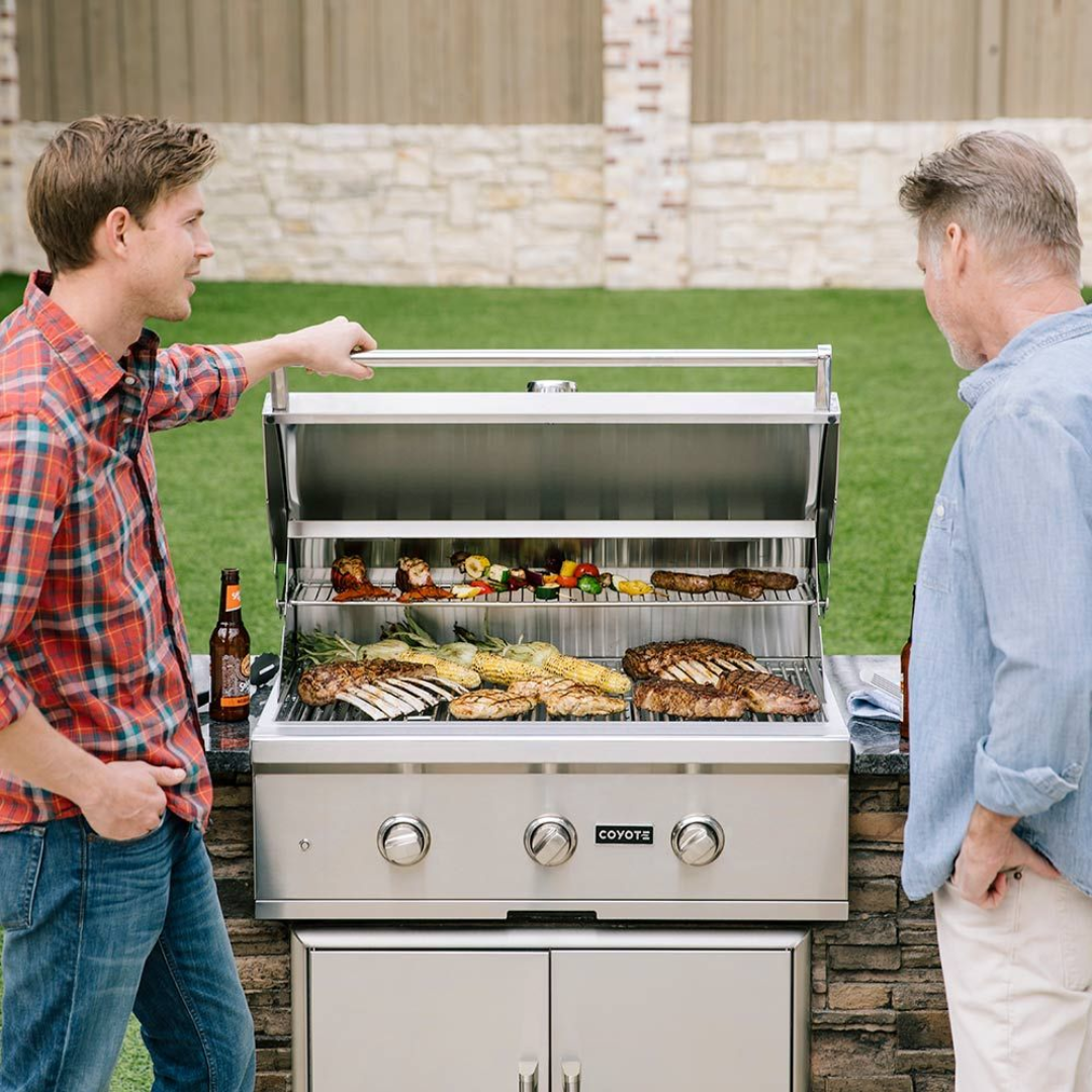 Two Men Talking Next to a Coyote Gas Grill